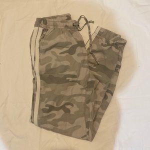 Jogger style camo pants with a white stripe and pockets.